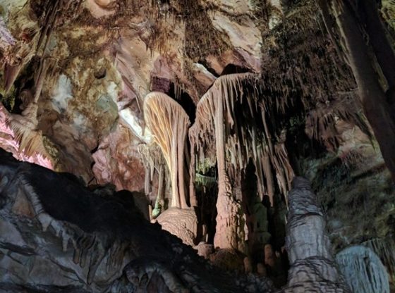 Stalactites and stalagmites illuminated in a cave